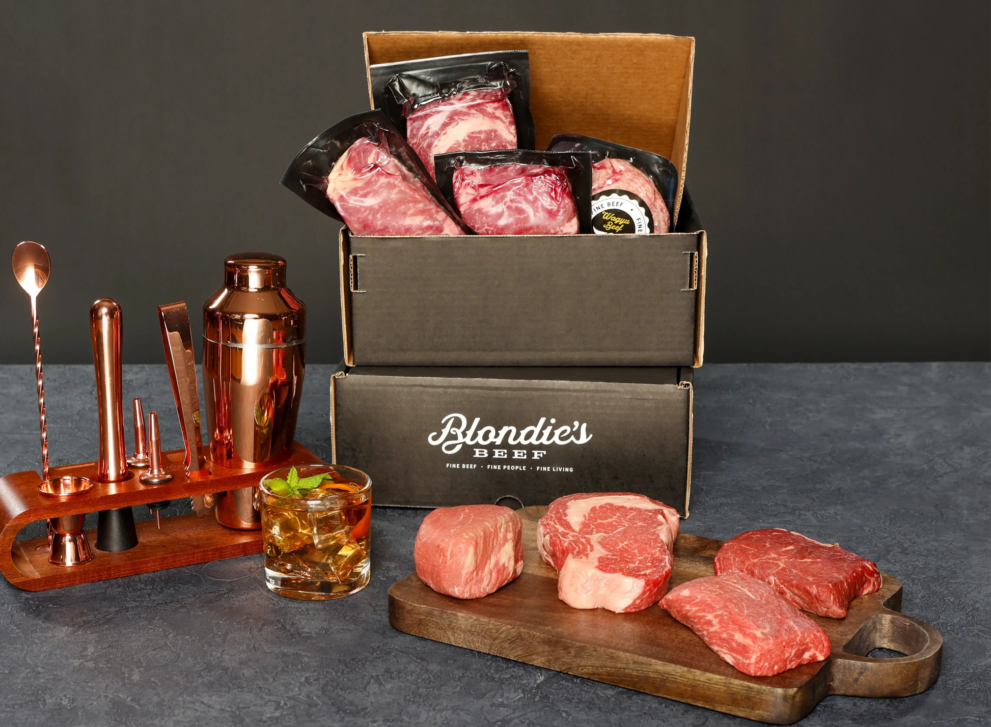 Blondie’s Beef Gold Level Box featuring premium Wagyu steaks with branded packaging. Positioned next to copper barware, and a whiskey glass for a luxury VIP dining experience.
